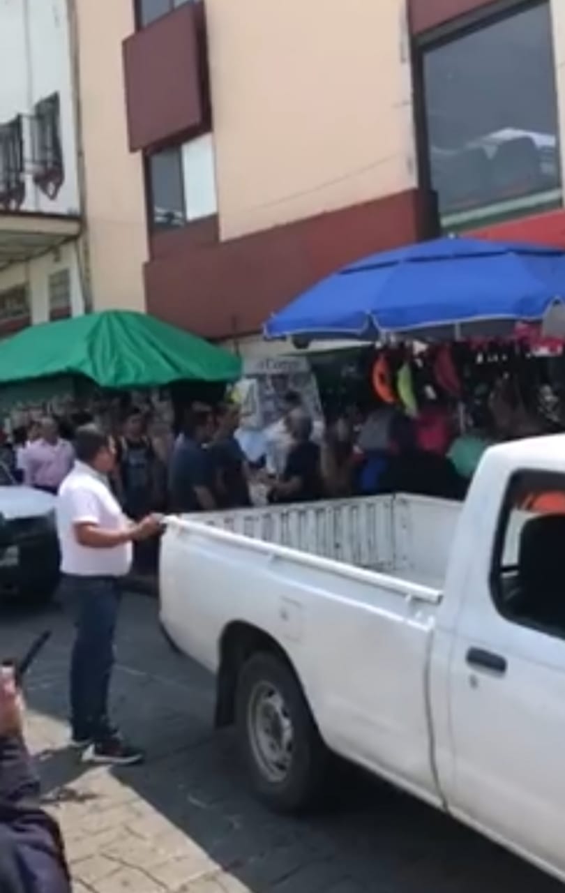 A golpes y recordatorios de  madre una mujer defiende su puesto ambulante